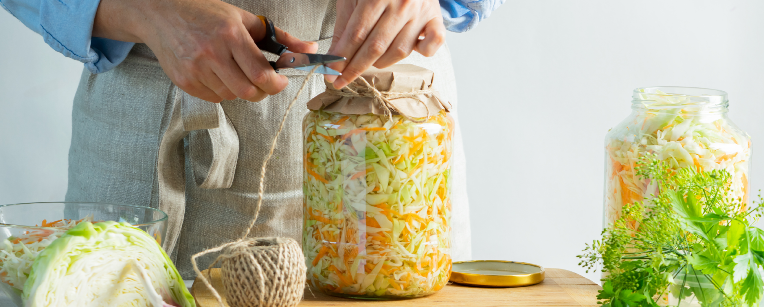 Frau die fermentiertes Kraut in Glas verpackt